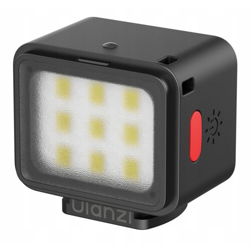Kwadratowa lampa LED z dziewięcioma widocznymi diodami, posiada czarną obudowę z czerwonym przyciskiem i symbolem słońca. Na podstawie lampy znajduje się napis "Ulanzi".