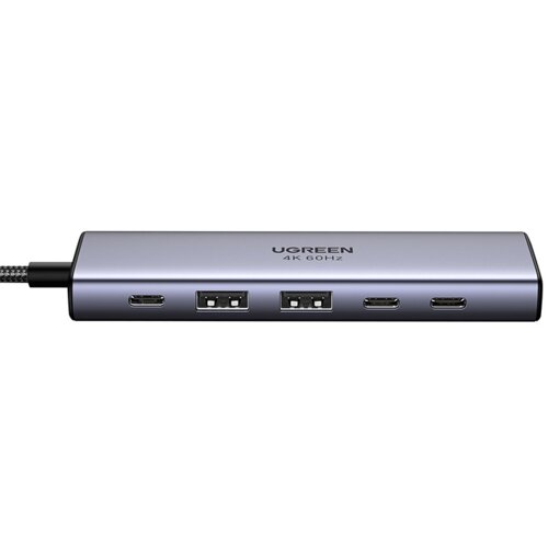 Na zdjęciu widoczny jest hub USB w kolorze srebrnym z sześcioma portami, w tym USB Typu C i USB Typu A. Na powierzchni urządzenia znajduje się napis "UGREEN 4K 60Hz".