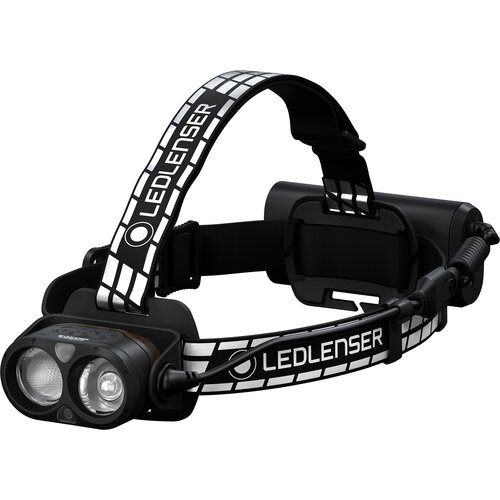 Czarna latarka czołowa z dwoma okrągłymi soczewkami, zamocowana na elastycznym pasku z białymi wzorami i napisem "LEDLENSER". Z tyłu znajduje się pojemnik na baterie, połączony z latarką za pomocą przewodu.