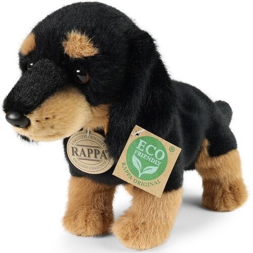 Pluszowa maskotka w kształcie jamnika z czarną i brązową sierścią, z dwoma zawieszkami. Jedna zawieszka z napisem "RAPPA" oraz druga z napisem "ECO FRIENDLY RAPPA ORIGINAL".
