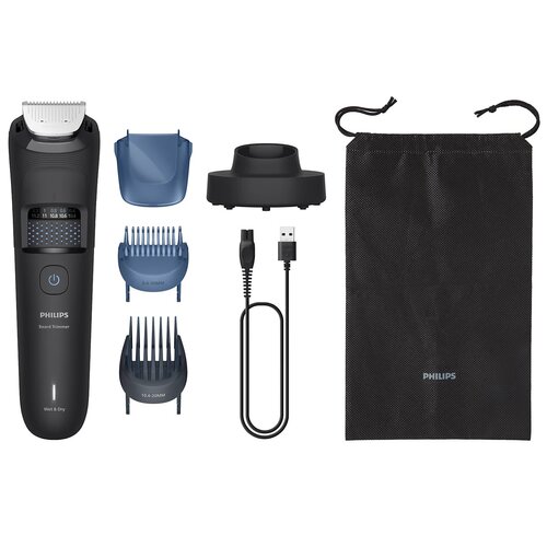Na zdjęciu znajduje się trymer z wyświetlaczem, dwie nasadki grzebieniowe, nasadka ochronna, stacja dokująca, kabel USB oraz czarny woreczek z napisem "PHILIPS". Na trymerze widoczny jest napis "PHILIPS Beard Trimmer" oraz "Wet & Dry".