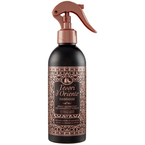 Czarno-miedziana butelka z atomizerem zawiera odświeżacz powietrza "Tesori d'Oriente Hammam" o pojemności 250 ml. Na etykiecie widnieje ozdobny wzór oraz napisy: "Spray Aromatico per Ambienti e Tessuti" i "Argan e Fiori d'Arancio".