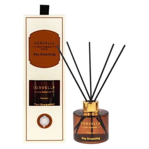 Brązowy flakon z patyczkami zapachowymi obok prostokątnego opakowania, na którym widnieje napis "SORVELLA Home Fragrance Premium Day Dreaming". Flakon ma złotą nakrętkę, a na jego etykiecie znajduje się ten sam napis co na opakowaniu.