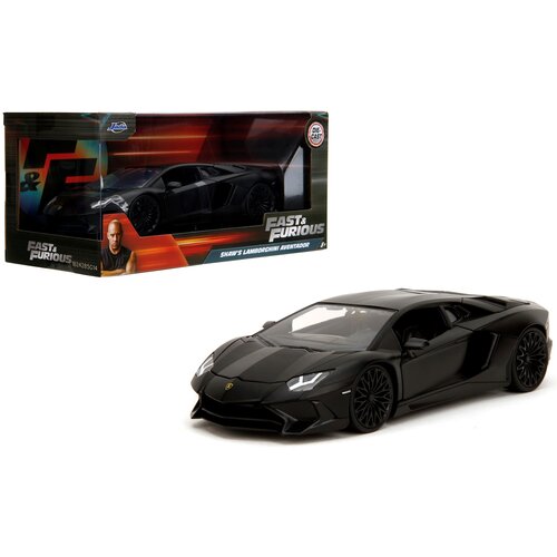 Na zdjęciu widoczny jest model samochodu w kolorze czarnym, obok którego znajduje się pudełko z napisem "Fast & Furious Shaw's Lamborghini Aventador". Na pudełku znajduje się również logo producenta Jada Toys oraz wizerunek postaci z filmu.