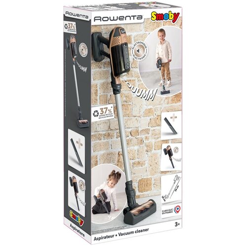 Opakowanie zabawki odkurzacza SMOBY Rowenta X Force 7600330223 z widocznym zdjęciem produktu oraz dziecka bawiącego się odkurzaczem na tle ceglanej ściany. Na opakowaniu znajdują się napisy: "Rowenta", "Smoby", "37% METAL", "ELECTRONIQUE", "SOUUMM", "Fabr