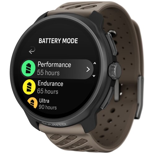 Na zdjęciu widoczny jest smartwatch z wyświetlaczem pokazującym tryby baterii: "BATTERY MODE" z opcjami "Performance 55 hours", "Endurance 65 hours" i "Ultra 90 hours". Pasek zegarka jest beżowy, a na obudowie widnieje logo "SUUNTO".