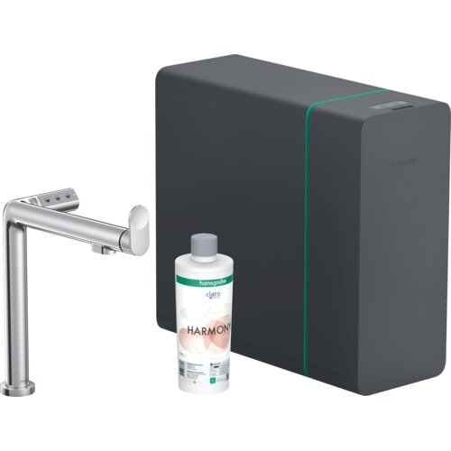 Na zdjęciu znajduje się chromowana bateria kuchenna, obok której stoi butelka z napisem "hansgrohe claro HARMONY" oraz ciemnoszare urządzenie z subtelnym zielonym akcentem i logo "hansgrohe".