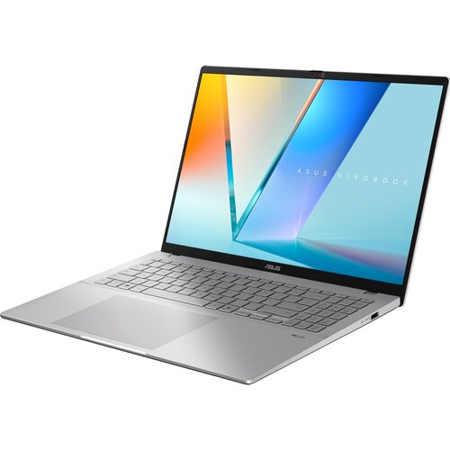 Na zdjęciu widoczny jest otwarty laptop z dużym ekranem, na którym wyświetlany jest kolorowy motyw z napisem "ASUS VIVOBOOK". Na obudowie poniżej klawiatury znajduje się logo "ASUS".
