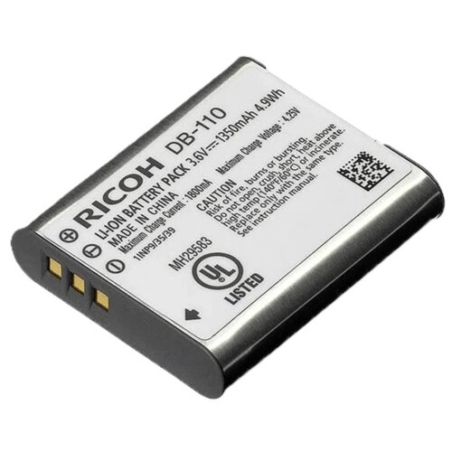 Akumulator RICOH DB-110 o pojemności 1350 mAh i napięciu 3.6V, z oznaczeniem UL LISTED, posiada widoczne złote styki oraz kod QR. Na etykiecie znajdują się informacje o produkcie, w tym ostrzeżenia dotyczące użytkowania i dane producenta.