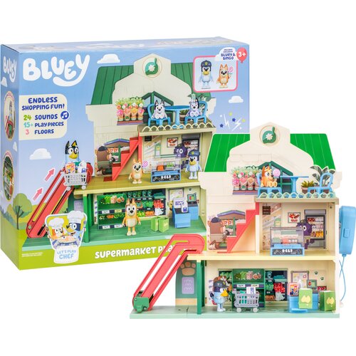 Na zdjęciu znajduje się zestaw figurek "BLUEY Supermarket BLU18918" przedstawiający dwupoziomowy supermarket z czerwonymi schodami, kasą, półkami z produktami oraz figurkami postaci. W tle widoczne jest opakowanie z napisem "BLUEY", "ENDLESS SHOPPING FUN!
