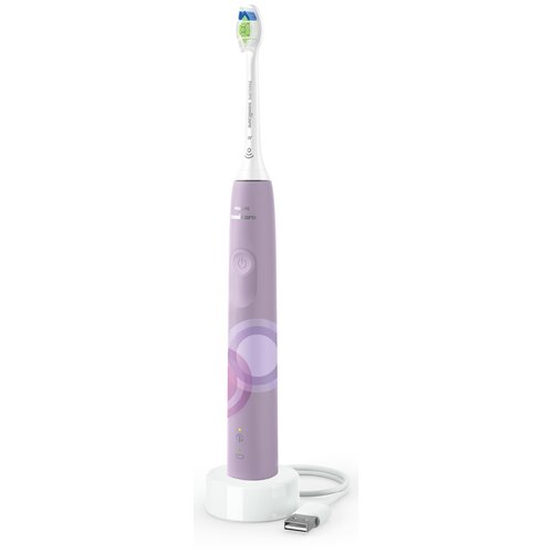 Fioletowa szczoteczka soniczna z białą główką, stojąca na białej podstawce z kablem USB. Na uchwycie widoczne są przycisk zasilania oraz logo "Philips Sonicare".