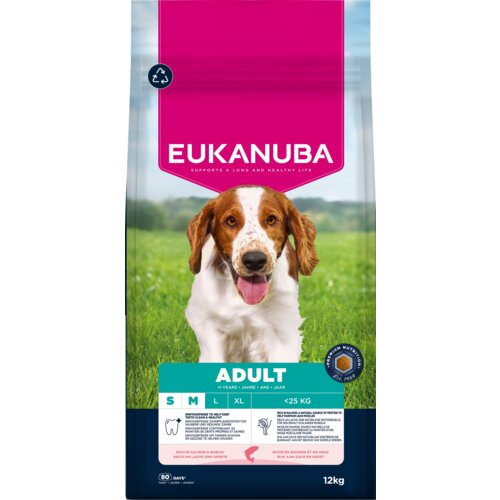 Opakowanie karmy dla psa EUKANUBA Adult Small and Medium Breed Łosoś 12 kg przedstawia zdjęcie psa na tle zielonej trawy, z dużym różowym napisem "EUKANUBA" oraz informacjami o produkcie, takimi jak "ADULT", "S M L", "<25 KG" i "12 kg". Na opakowaniu widn