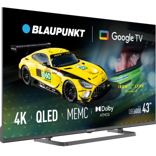 Na zdjęciu widoczny jest telewizor z wyświetlonym obrazem żółtego samochodu wyścigowego oraz tekstem: "BLAUPUNKT", "Google TV", "4K", "QLED", "MEMC", "Dolby ATMOS", "Series QBG6000", "43”". W tle znajduje się zbliżenie na twarz osoby w kasku, a obok logo 