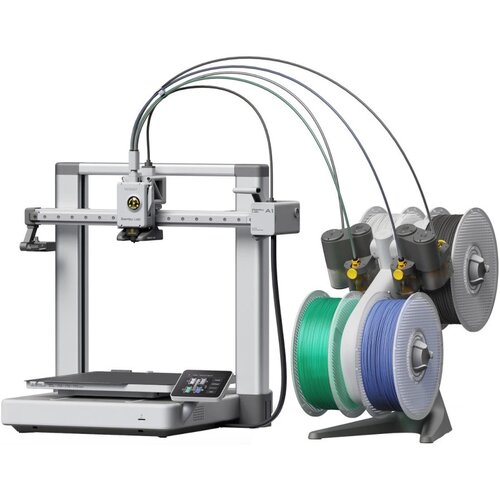 Na zdjęciu znajduje się drukarka 3D z kilkoma szpulami filamentu w różnych kolorach, połączonymi przewodami z urządzeniem. Na obudowie drukarki widoczny jest napis "Bambu Lab" oraz "A1".