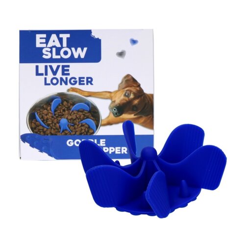 Na zdjęciu znajduje się niebieski wkład do miski o nieregularnym kształcie, a w tle widoczny jest karton z napisem "EAT SLOW LIVE LONGER" oraz zdjęciem psa i miski z karmą. Na opakowaniu znajduje się również napis "GOBBLE STOPPER".