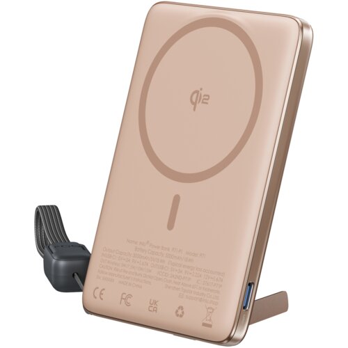 Beżowy powerbank indukcyjny z widocznym logo "qi2" na powierzchni oraz tekstem technicznym na dole, zawierającym specyfikacje i certyfikaty, takie jak CE, FCC, UKCA. Po bokach widoczne są porty oraz pasek do przenoszenia.