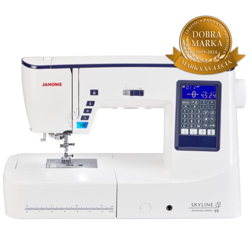 Na zdjęciu znajduje się maszyna do szycia z wyświetlaczem i przyciskami, oznaczona jako "JANOME Skyline S5 Anniversary Edition". W prawym górnym rogu widoczna jest odznaka z napisem "DOBRA MARKA 2009-2024 MARKA XV-LECIA".