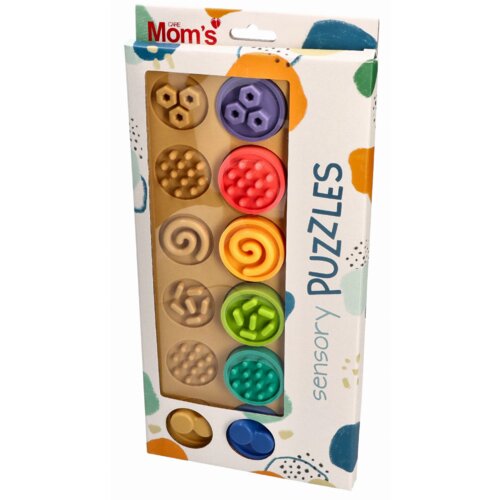Opakowanie zawiera zestaw kolorowych klocków sensorycznych o różnych fakturach i kształtach, z widocznym logo "Mom's Care" w lewym górnym rogu. Na opakowaniu znajduje się napis "sensory PUZZLES" oraz kolorowe wzory w tle.