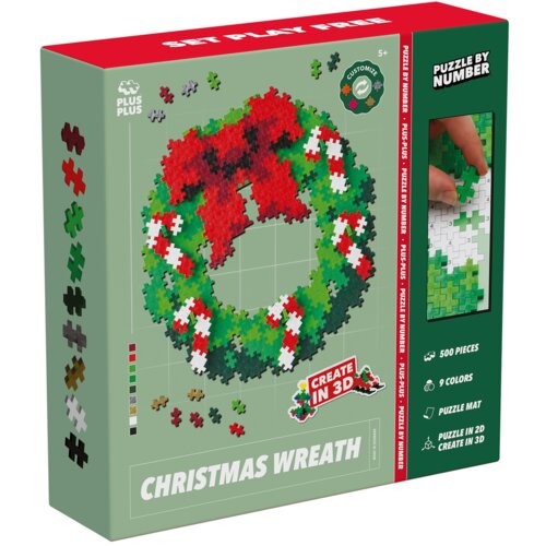 Pudełko z klockami plastikowymi przedstawia kolorowy wieniec świąteczny złożony z klocków w różnych kolorach, z napisem "CHRISTMAS WREATH" na dole. Na opakowaniu widnieją informacje: "500 pieces", "9 colors", "Create in 3D", oraz logo "PLUS PLUS".