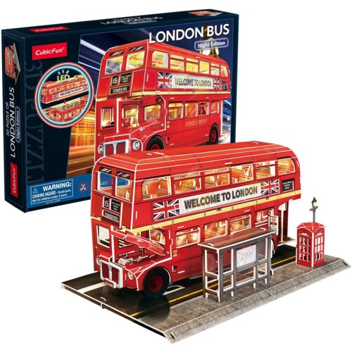 Na zdjęciu znajduje się model 3D czerwonego londyńskiego autobusu z napisem "WELCOME TO LONDON" oraz flagą brytyjską, umieszczony na podstawce z przystankiem i budką telefoniczną. W tle widoczne jest opakowanie z napisem "LONDON BUS Night Edition" oraz lo