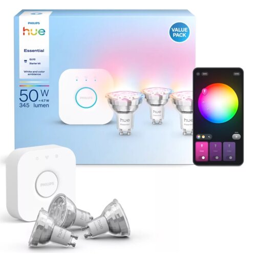 Na zdjęciu znajduje się opakowanie zestawu "PHILIPS hue Essential GU10 Starter kit" z trzema żarówkami LED oraz mostkiem, obok widoczny jest interfejs aplikacji na smartfonie z kołem kolorów. Na opakowaniu widnieje napis "50 W = 4.7 W, 345 lumen", a w rog