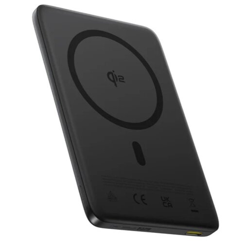Czarny powerbank z widocznym logo "qi2" na powierzchni, posiada okrągły wzór oraz kilka oznaczeń certyfikacyjnych, takich jak CE i UKCA. Na dolnej krawędzi znajduje się port USB w kolorze żółtym.