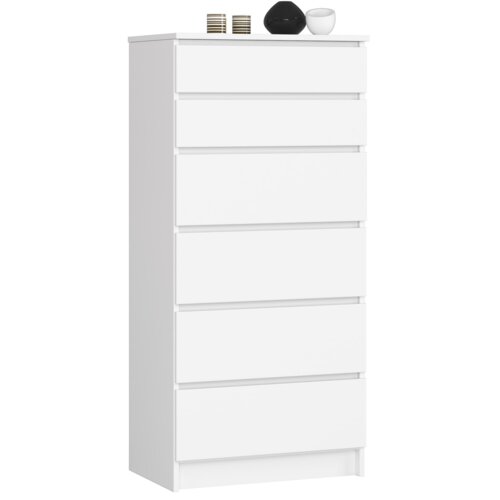 Biała komoda z sześcioma szufladami, o matowym wykończeniu, na której blacie znajdują się dwa ozdobne pojemniki i czarna kula. Produkt ma wymiary 60x40x130 cm.
