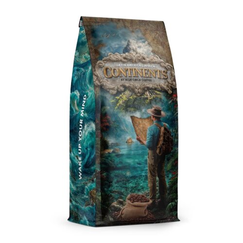 Opakowanie kawy ziarnistej "BLUE ORCA COFFEE Continents 2 Latin America & Africa 1 kg" przedstawia ilustrację podróżnika z mapą, stojącego nad wodą, z workiem pełnym ziaren kawy u jego stóp. Na boku opakowania widnieje napis "WAKE UP YOUR MIND".