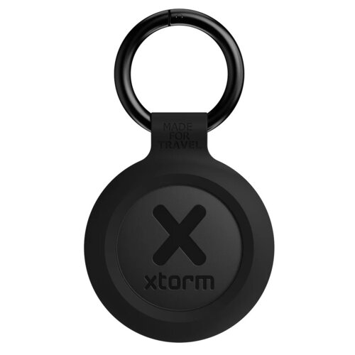 Czarny lokalizator w kształcie okręgu z napisem "xtorm" oraz dużą literą "X" na środku, posiada metalowy pierścień u góry z wygrawerowanym napisem "MADE FOR TRAVEL".