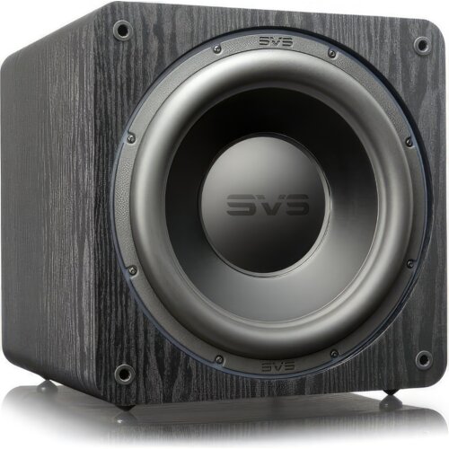 Czarny subwoofer z widocznym logo "SVS" na przednim panelu, umieszczony na drewnianej obudowie o wyraźnej teksturze. Produkt ma okrągły głośnik z metalicznym wykończeniem.
