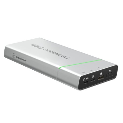 Srebrny powerbank z logo "GREENCELL" na górnej powierzchni, z zieloną linią biegnącą wzdłuż obudowy. Na boku widoczny jest napis "airplane ready", a na przednim panelu znajdują się różne porty i przyciski, w tym oznaczenia "PD" i ikony związane z ładowaniem.