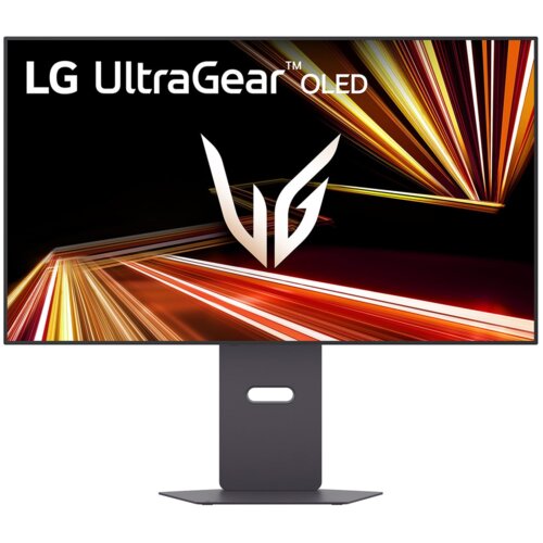 Monitor z dużym ekranem wyświetla dynamiczną grafikę z jasnymi, kolorowymi liniami na czarnym tle. W lewym górnym rogu widoczny jest napis "LG UltraGear OLED", a na środku ekranu znajduje się logo "VG".