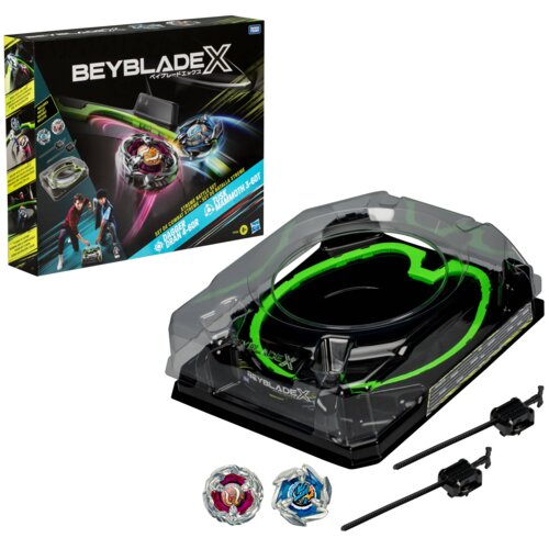 Pudełko z napisem "BEYBLADE X" zawiera ilustracje dwóch wirujących bączków oraz dwóch postaci w dynamicznych pozach. Obok znajduje się przezroczysta arena z zielonymi akcentami, dwa bączki oraz dwa wyrzutniki.