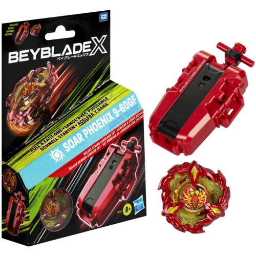 Opakowanie zabawki Beyblade X z wyrzutnią i bączkiem Soar Phoenix 9-60GF, z widocznym logo Hasbro i napisami: "PULL FAST ONE-LANCE AVEC PUISSANCE", "SOAR PHOENIX 9-60GF", "DELUXE STRING LAUNCHER SET". Obok opakowania znajdują się czerwona wyrzutnia i bącz