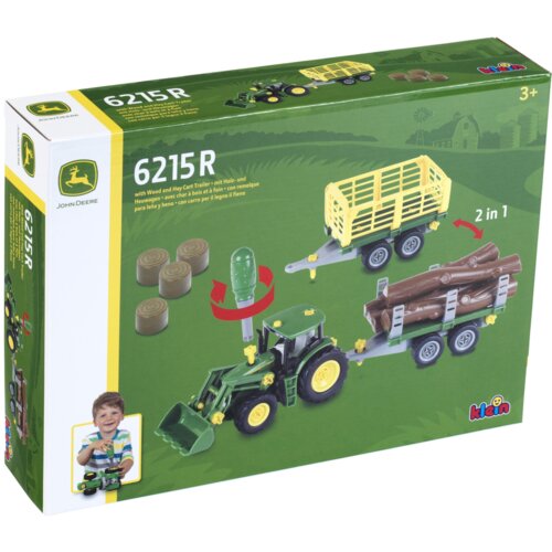 Zielone pudełko z zabawkowym traktorem i przyczepą, na którym widnieje napis "6215 R" oraz logo John Deere. Na opakowaniu znajduje się również zdjęcie dziecka bawiącego się zabawką i logo "klein".