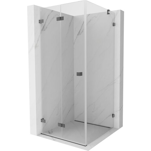 Na zdjęciu znajduje się składana kabina prysznicowa o wymiarach 90 x 90 cm, wykonana z transparentnego szkła z elementami w kolorze szczotkowanego szarego metalu. Kabina jest umieszczona na tle imitującym marmur.