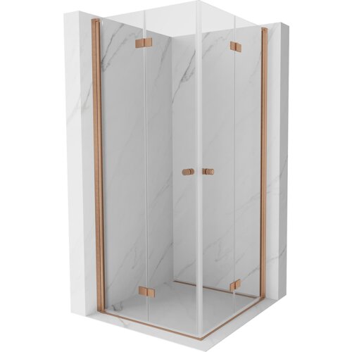 Kabina prysznicowa o wymiarach 90 x 90 cm z transparentnym szkłem i elementami w kolorze miedzi szczotkowanej, umieszczona na tle ścian z jasnego marmuru. Produkt ma składane drzwi z miedzianymi uchwytami i zawiasami.