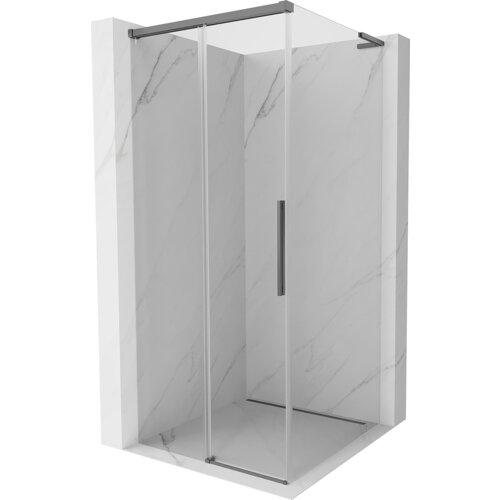 Na zdjęciu znajduje się kabina prysznicowa z przezroczystymi, przesuwanymi drzwiami i metalowymi elementami w kolorze gun metal, umieszczona w narożniku wyłożonym płytkami o marmurowym wzorze. Kabina ma prostokątny kształt i nowoczesny design.