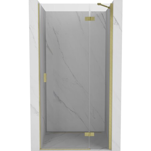 Drzwi prysznicowe uchylne o transparentnej powierzchni, z elementami w kolorze złotym szczotkowanym, zamontowane w marmurowej wnęce. Produkt ma elegancki, minimalistyczny design z widocznymi złotymi zawiasami i uchwytami.