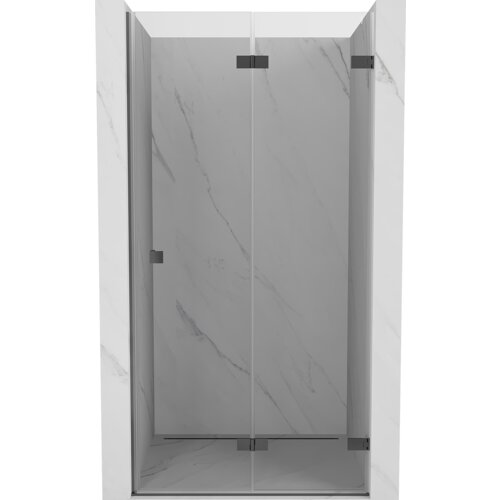 Na zdjęciu widoczne są składane drzwi prysznicowe w kolorze gun metal, z przezroczystym szkłem, zamontowane w marmurowej wnęce. Drzwi mają prosty, nowoczesny design z metalowymi zawiasami.