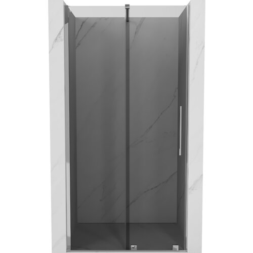 Drzwi prysznicowe rozsuwane o szerokości 110 cm, w kolorze grafitowym z chromowanymi elementami, umieszczone w marmurowej wnęce. Produkt ma prosty, nowoczesny design z pionowym uchwytem.
