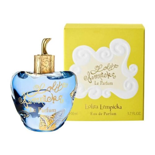 Na zdjęciu widoczna jest niebieska butelka perfum o kształcie przypominającym jabłko, z złotym napisem "Lolita Lempicka Le Parfum" oraz złotym korkiem. W tle znajduje się żółte pudełko z białym ornamentem i napisem "Lolita Lempicka Le Parfum" oraz informacją o pojemności "50 ml" i "1.7 FL.OZ.".