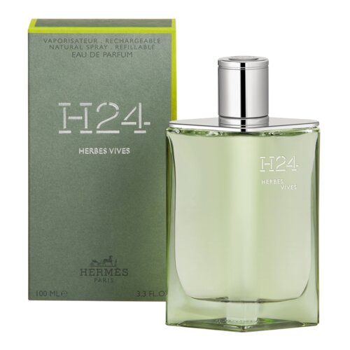 Na zdjęciu widoczna jest butelka perfum o zielonkawym odcieniu z napisem "H24 Herbes Vives" oraz opakowanie z napisem "Vaporisateur, Rechargeable, Natural Spray, Refillable, Eau de Parfum" i logo "Hermes Paris". Pojemność produktu to 100 ml, co jest również widoczne na opakowaniu.