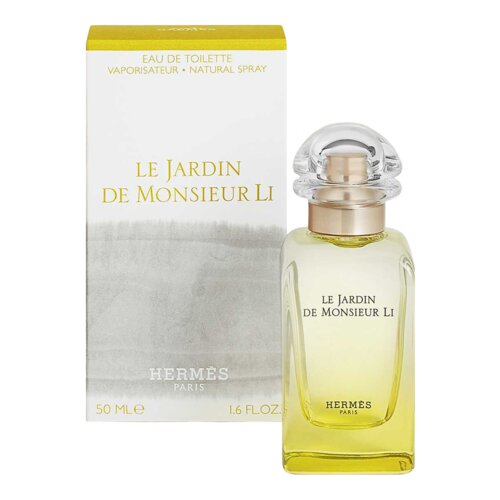 Flakon perfum o pojemności 50 ml z przezroczystym korkiem stoi przed pudełkiem, na którym widnieje napis "LE JARDIN DE MONSIEUR LI" oraz "HERMES PARIS". Na dole pudełka znajduje się informacja "50 ML e 1.6 FL.OZ."