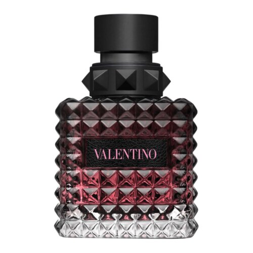 Kwadratowy flakon perfum o fakturze przypominającej diamenty, z czarnym korkiem i etykietą z napisem "VALENTINO" w różowym kolorze. Flakon ma ciemnoróżowy odcień w górnej części, przechodzący w przezroczysty na dole.