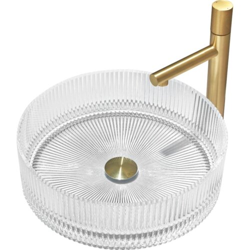 Przezroczysta, szklana umywalka nablatowa o wymiarach 39 x 39 cm z widocznymi pionowymi żłobieniami na zewnętrznej powierzchni. Umywalka posiada złoty korek odpływowy i złotą baterię z prostym wylewem.