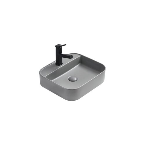 Szara, matowa umywalka nablatowa o zaokrąglonych krawędziach z czarną baterią. Umywalka ma prostokątny kształt z widocznym otworem odpływowym.