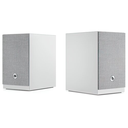Dwa białe głośniki o prostokątnym kształcie z szarą, teksturowaną przednią osłoną, na której znajduje się okrągłe logo. Głośniki są ustawione obok siebie na białym tle.