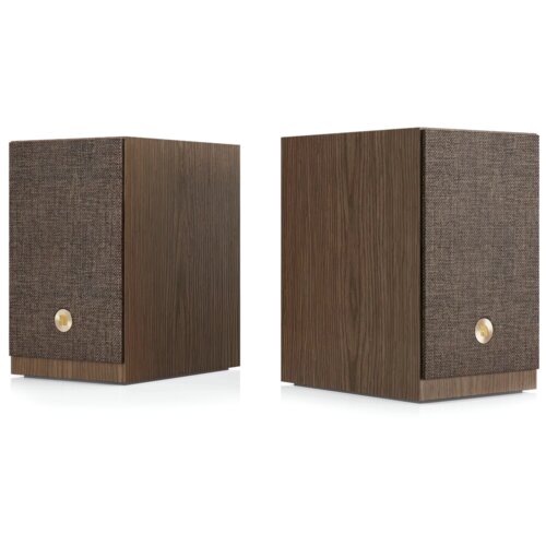 Dwa kolumny głośnikowe w kolorze orzechowym z przodu pokryte są ciemnym materiałem, na którym znajduje się okrągły, złoty element. Obudowa ma wyraźną teksturę drewna.