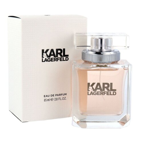 Na zdjęciu widoczna jest butelka perfum oraz pudełko z napisem "KARL LAGERFELD" i "EAU DE PARFUM 85 ml e 2.8 FL.OZ.". Butelka ma przezroczysty korek i zawiera płyn w jasnym, różowym odcieniu.
